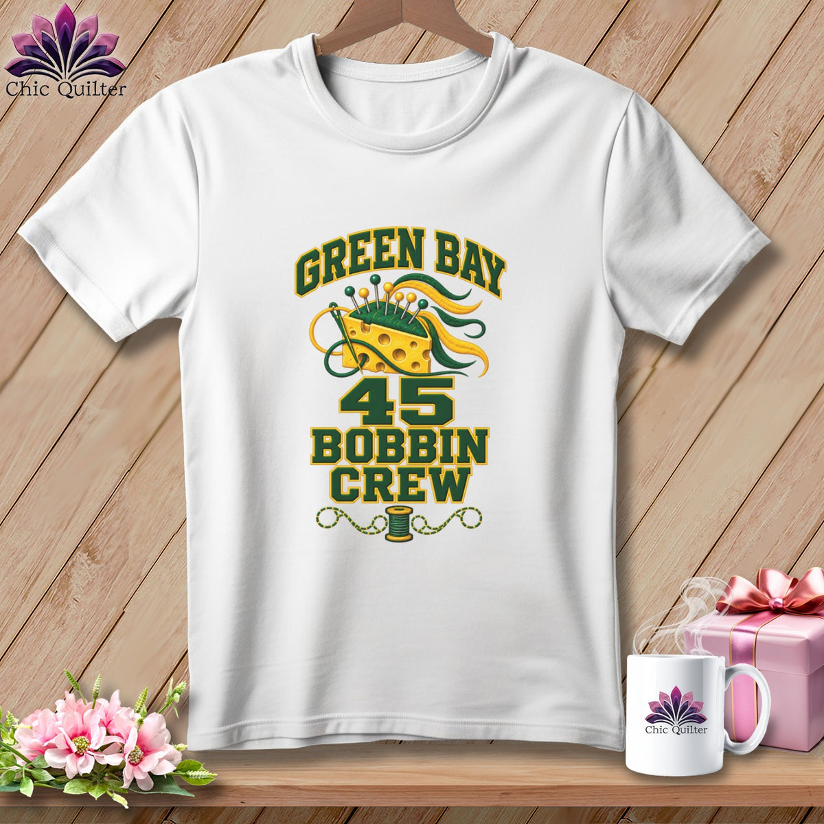White t-shirt featuring a green and yellow Green Bay 45 Bobbin Crew design on a wooden background.