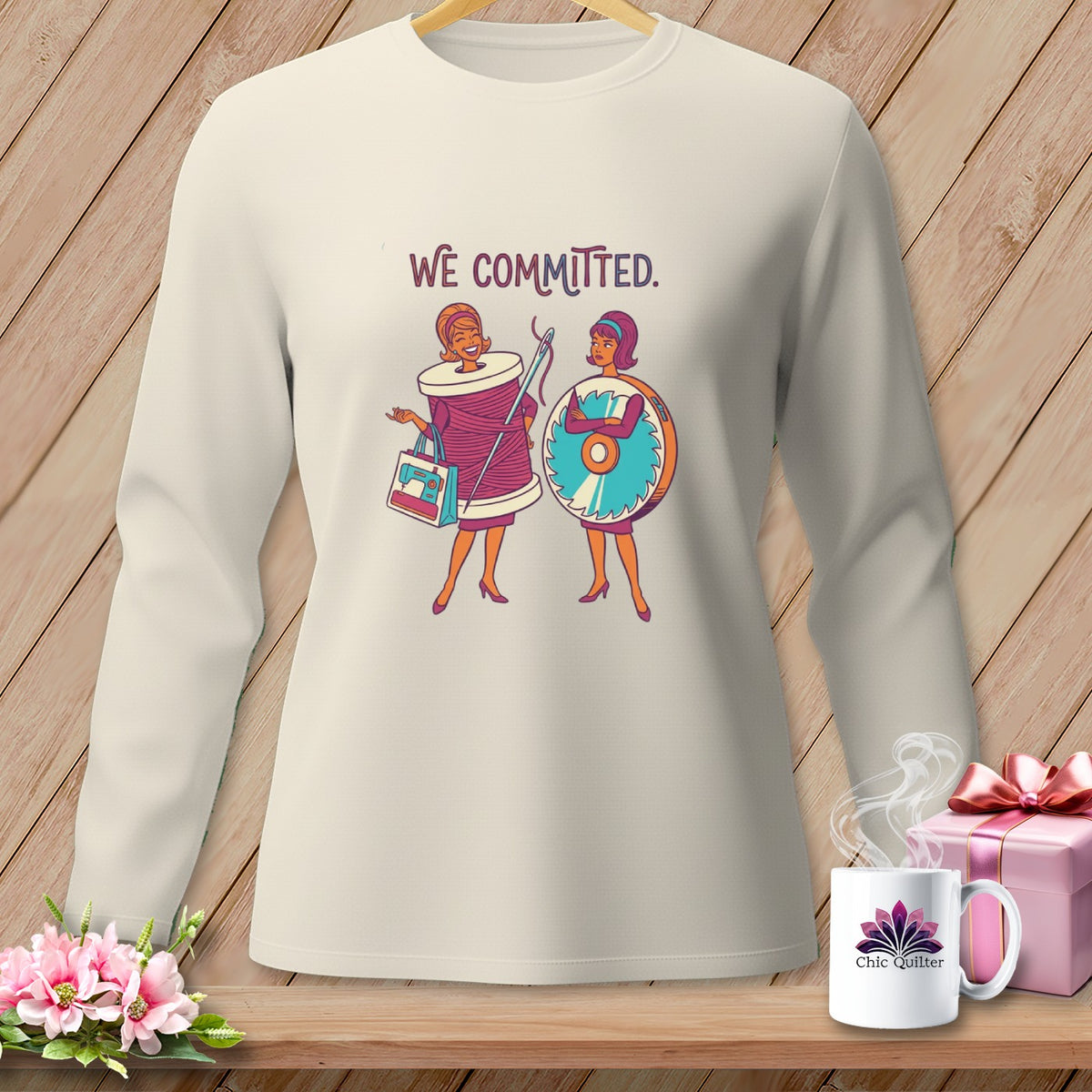 Long sleeve shirt with graphic of two women, one a spool of thread, other a sewing machine.