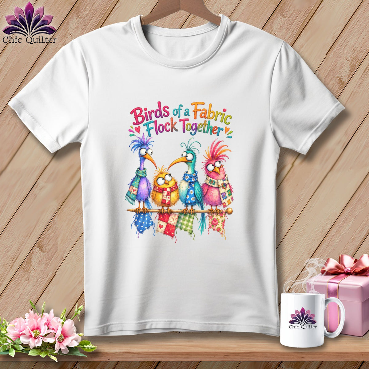 White t-shirt featuring a colorful graphic of four whimsical birds and the text Birds of a Fabric Flock Together.