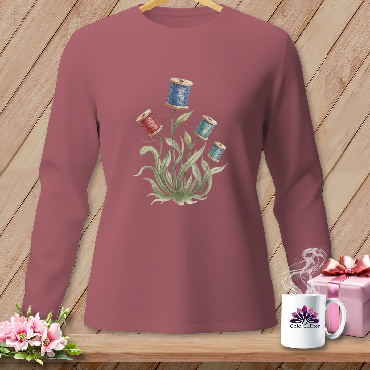Rose long-sleeved shirt with spool of thread floral graphic.