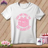 A white crewneck t-shirt featuring a pink graphic of a stack of folded fabric tied with a ribbon and the text Stop and Smell the Fat Quarters.