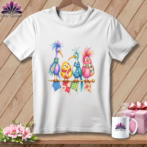 A white short-sleeved t-shirt features a colorful illustration of four quirky cartoon birds wearing patterned scarves.