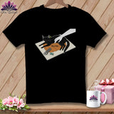 Black t-shirt with a black cat lying on a pumpkin, sewing tools, and the word HELPING.