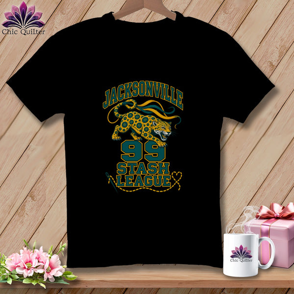 Black t-shirt featuring a Jacksonville 99 Stash League graphic with a spotted cat and sewing elements.
