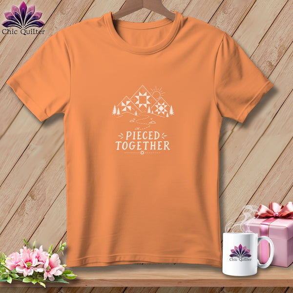 Orange t-shirt with "Pieced Together" text and mountain quilt design.