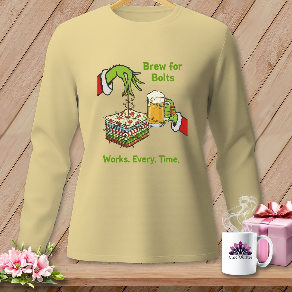 Grinch hands hold fabric stack and beer mug with text "Brew for Bolts Works. Every. Time."
