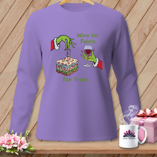 Purple long-sleeve shirt with Grinch hands, fabric stack, wine, and text.