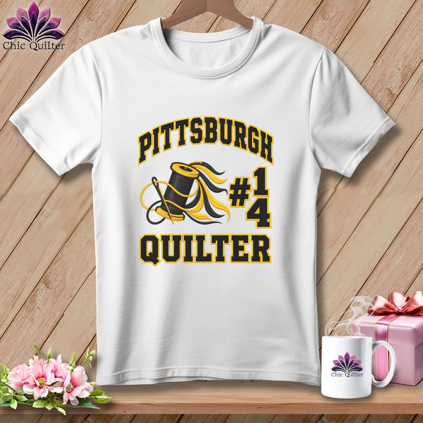 White crewneck t-shirt with black and yellow Pittsburgh Quilter text, a spool, needle, and a 1/4 icon.