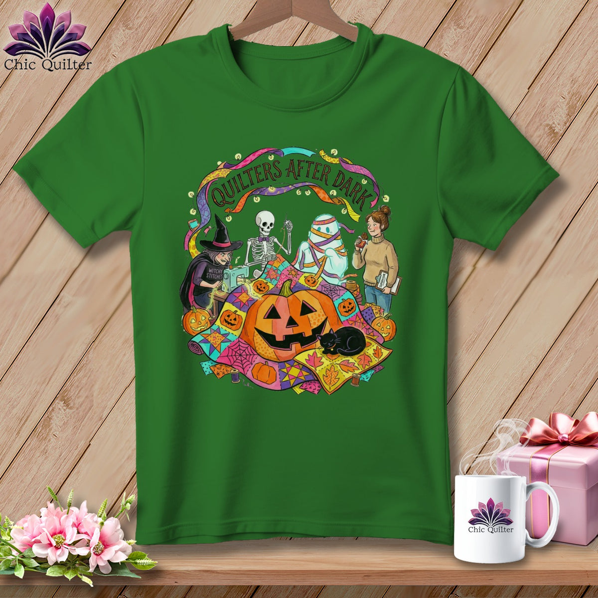 Green t-shirt featuring "Quilters After Dark" Halloween graphic with skeleton, mummy, and witch.