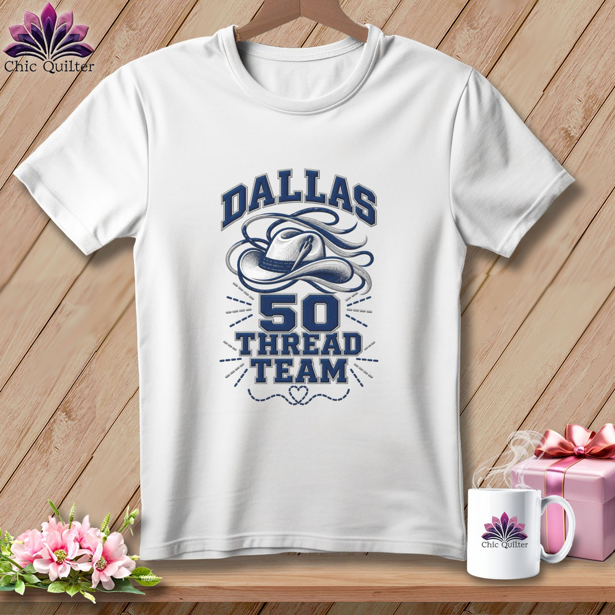A white crewneck t-shirt featuring a blue graphic of a cowboy hat, the text Dallas 50 Thread Team, and a stitched heart design.