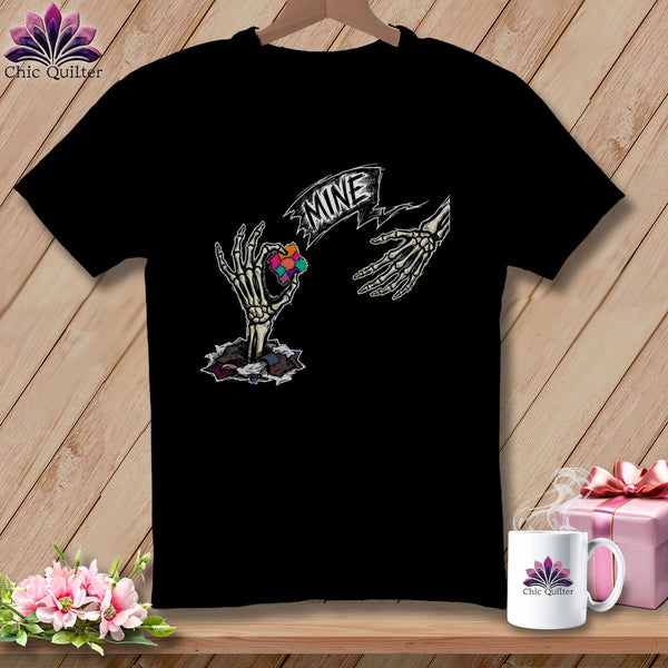Black t-shirt with skeleton hands reaching for a colorful patchwork square labeled "MINE".