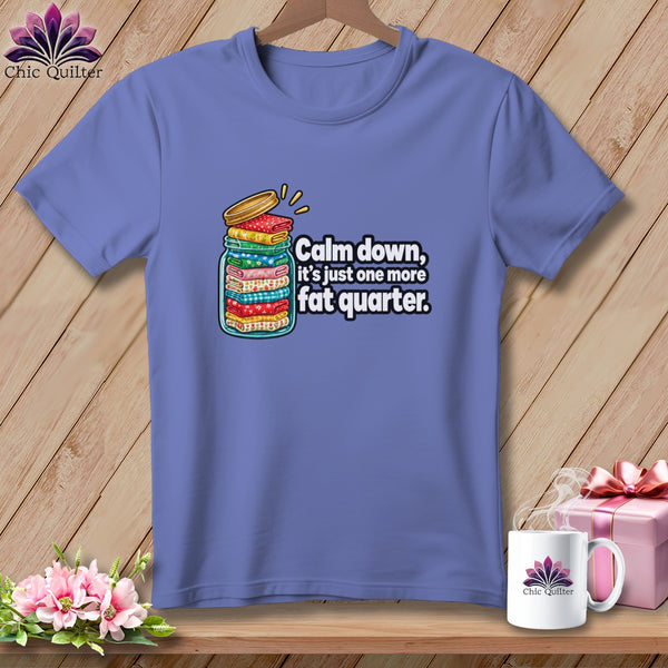 A periwinkle t-shirt features a graphic of a jar overflowing with folded fabric and text reading, Calm down, its just one more fat quarter.