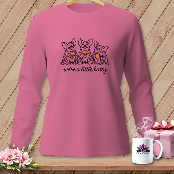 Pink long-sleeve shirt with three cartoon bats holding wine glasses and the text "we're a little batty."