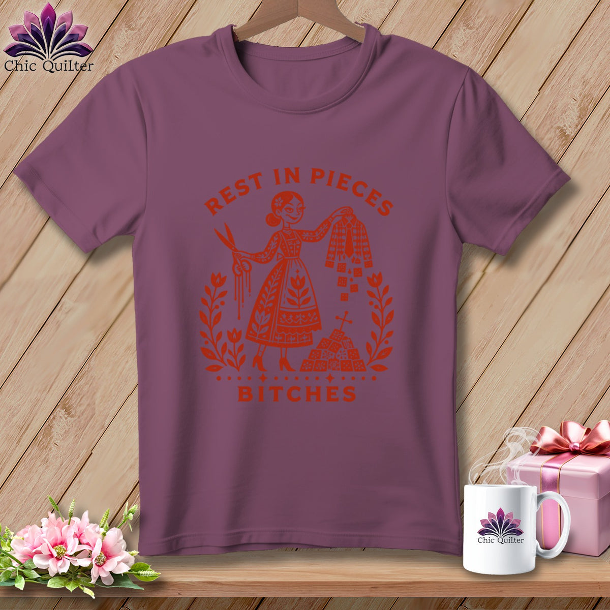 Purple t-shirt with orange graphic of a woman holding scissors and quilt blocks, reading "Rest in Pieces Bitches."