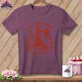 Purple t-shirt with orange graphic of a woman holding scissors and quilt blocks, reading 