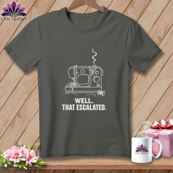 Dark grey t-shirt with white line art of a sewing machine and text: "WELL. THAT ESCALATED."