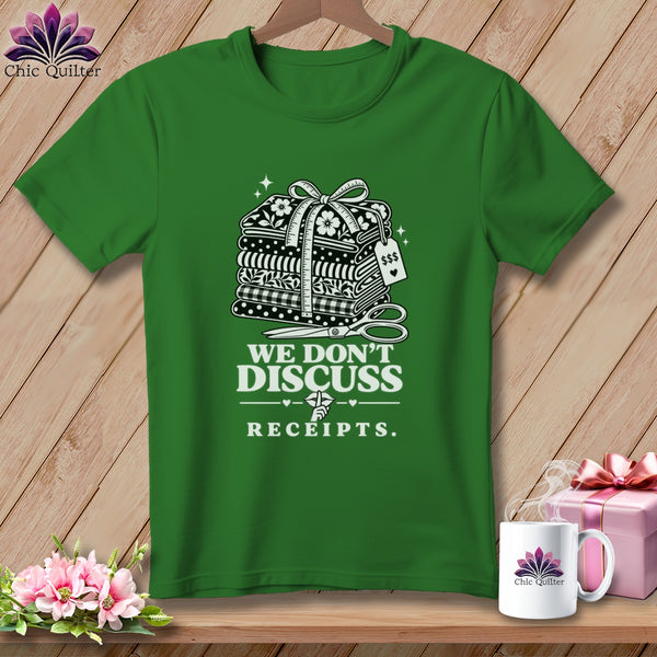 Green t-shirt with stacked fabric, scissors, and text "We Don't Discuss Receipts."