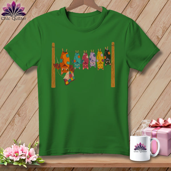 Green t-shirt with quilt-like bats hanging on a clothesline.