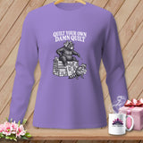 Purple long-sleeve t-shirt with a graphic of a bear and raccoon on quilts and text reading Quilt Your Own Damn Quilt.