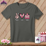 Dark grey t-shirt featuring a quilting graphic and the text Peace Love Fabric on a wooden background.