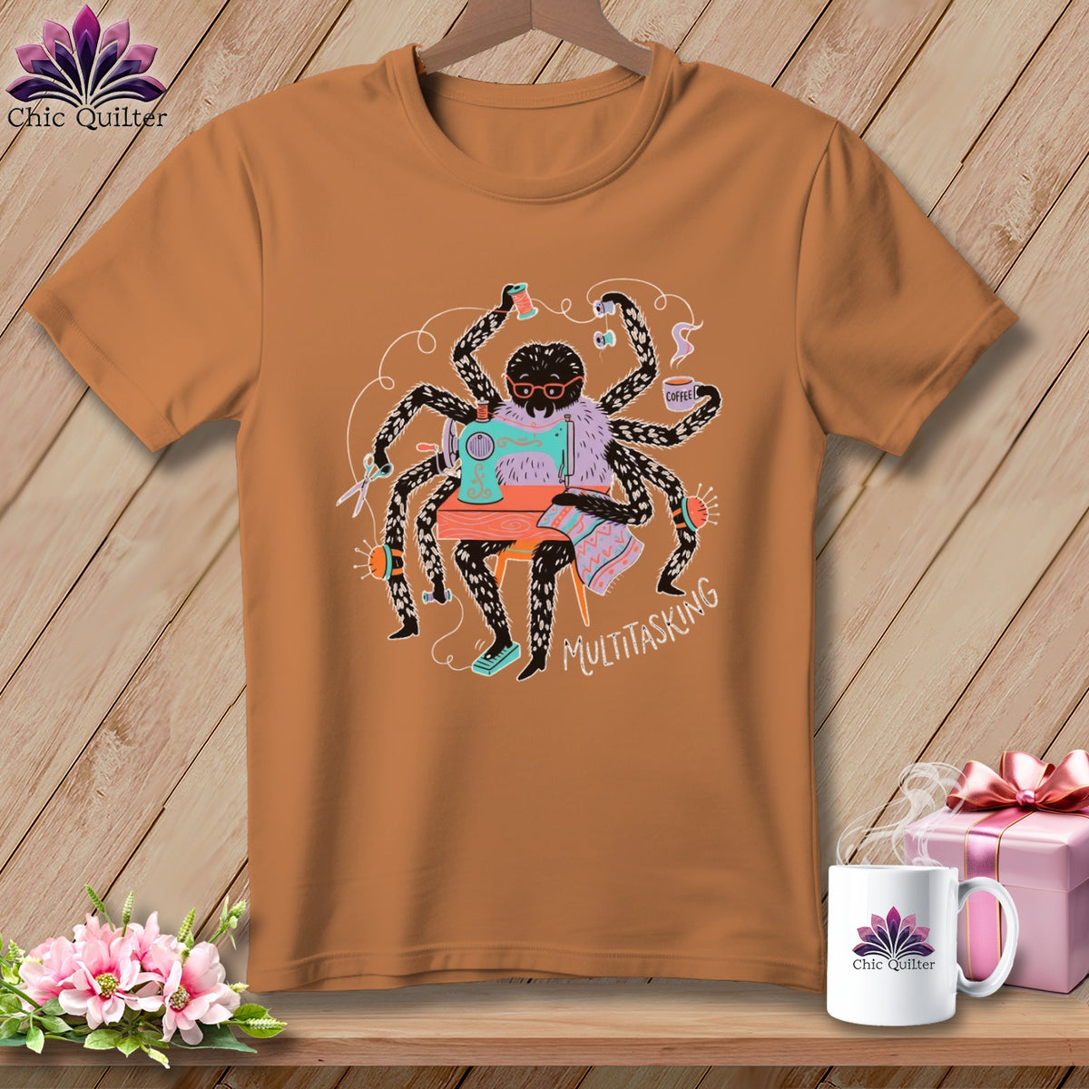 Brown t-shirt featuring a spider sewing with multiple arms, holding coffee, text "MULTITASKING".
