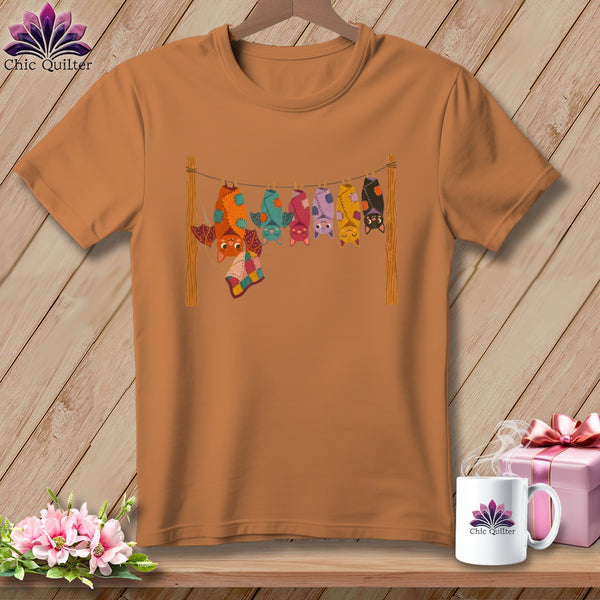 Orange t-shirt with a graphic of colorful bats hanging on a clothesline.