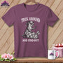 Mauve t-shirt on a wooden hanger with a graphic of an otter quilting a bunny and the text Tuck Around And Find Out.
