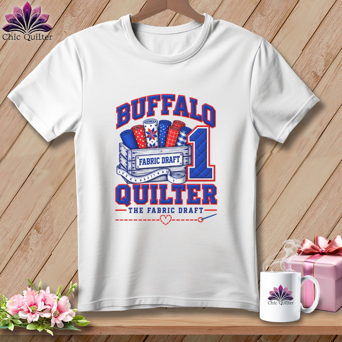White t-shirt printed with Buffalo Quilter graphic featuring fabric rolls in a wooden crate.