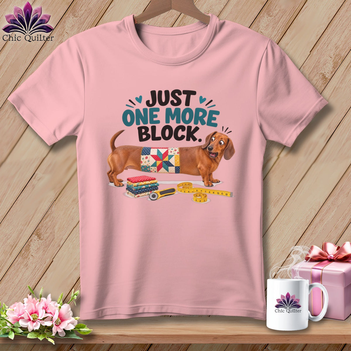 Pink t-shirt with dachshund wearing quilt block and text "JUST ONE MORE BLOCK".