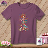 Mauve crewneck t-shirt featuring a whimsical illustration of a woman in a patchwork dress with a cat.