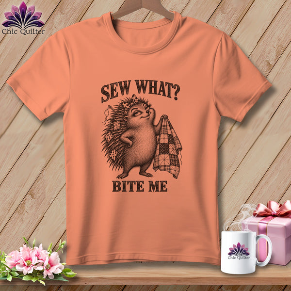 An orange crewneck t-shirt featuring a hedgehog holding a quilt with text reading Sew What? Bite Me.