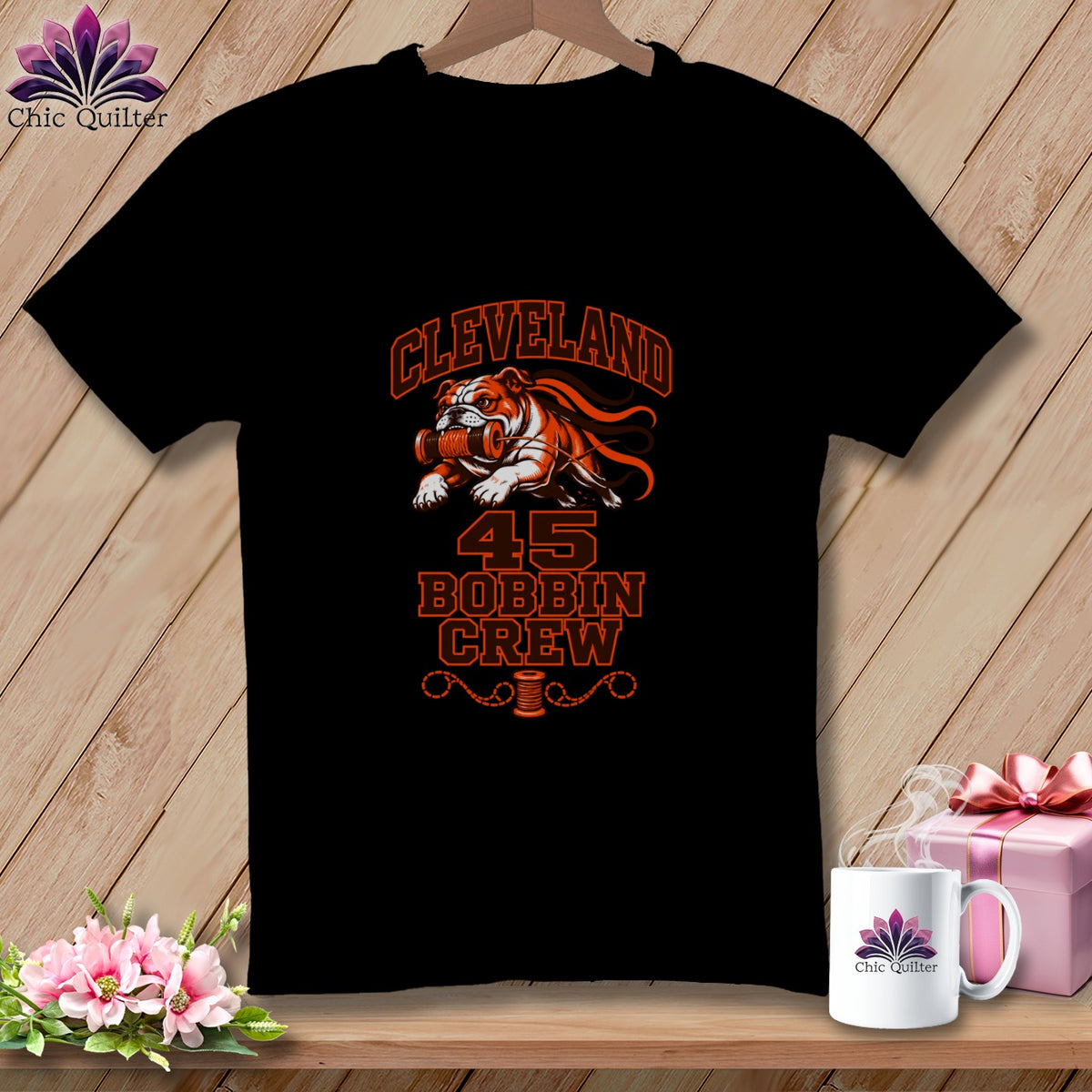 Black t-shirt featuring an orange graphic of a bulldog holding a thread spool, text reading Cleveland 45 Bobbin Crew.