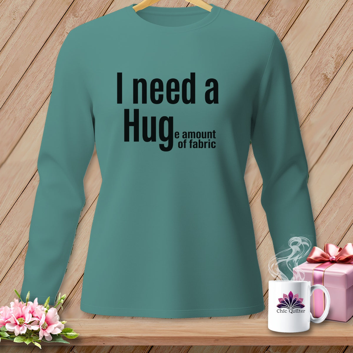 Teal long-sleeve shirt with black text "I need a Hug... the amount of fabric".