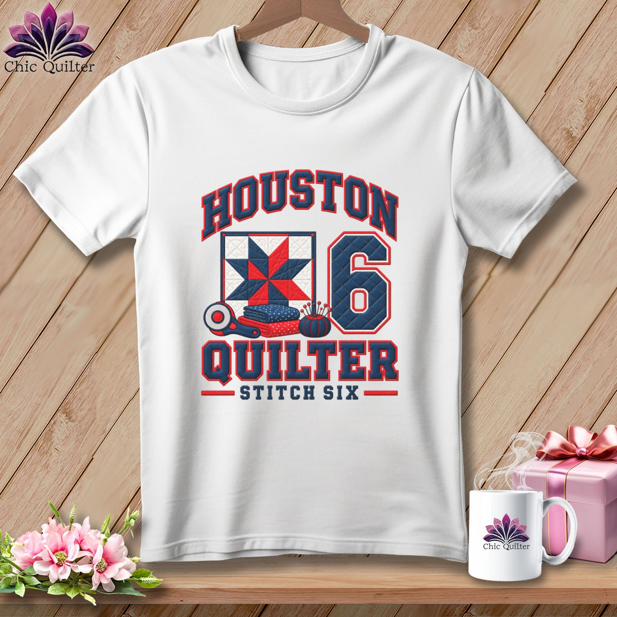 A white short-sleeved t-shirt with a blue and red graphic featuring the text Houston Quilter Stitch Six, a quilt block, and the number six.