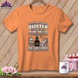 An orange short-sleeve t-shirt with text and graphics about quilting printed on the front.