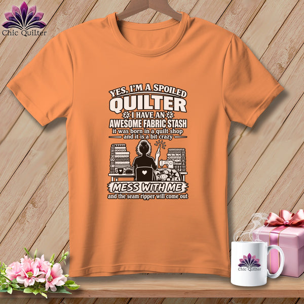An orange short-sleeve t-shirt with text and graphics about quilting printed on the front.