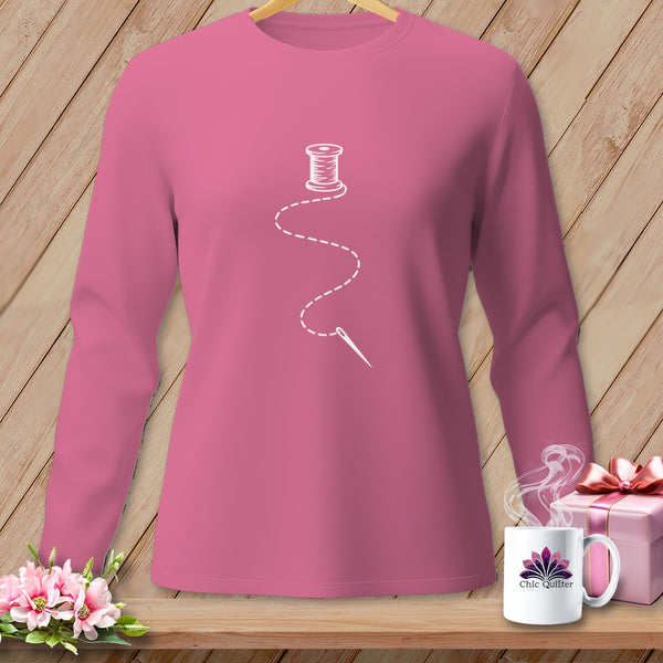 Pink long-sleeved shirt with white spool of thread and needle graphic.