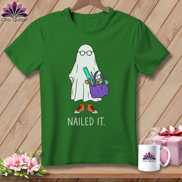 Green t-shirt with a ghost wearing glasses and holding a bag of sewing supplies.