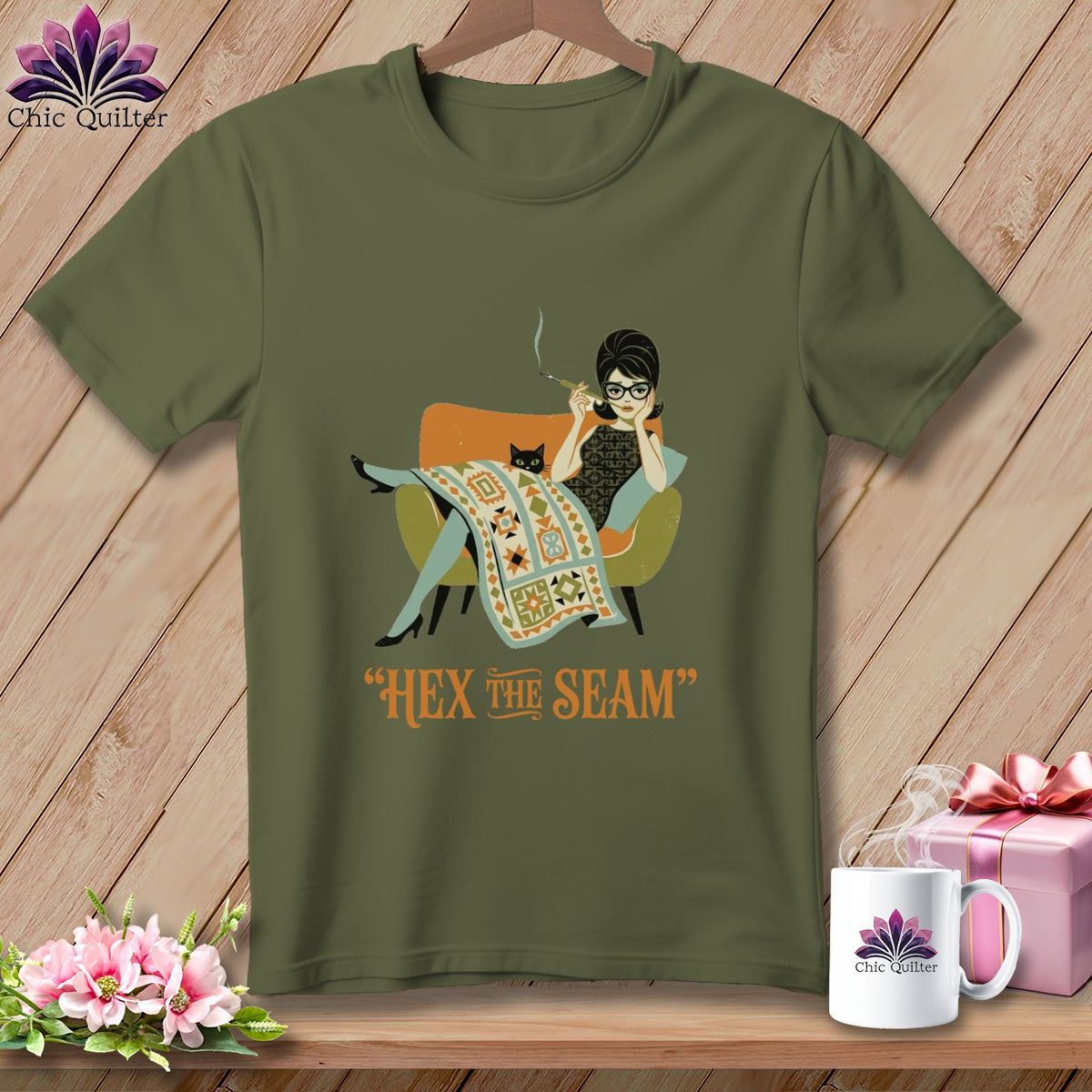 Olive t-shirt with graphic of woman, cat, and quilt, saying "Hex the Seam".
