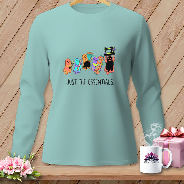 Light blue long-sleeve shirt with colorful ghosts holding sewing notions and "JUST THE ESSENTIALS." text.