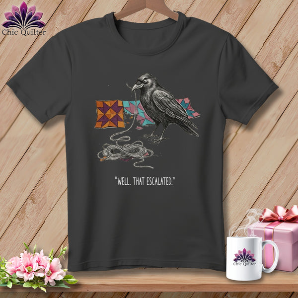 Dark t-shirt with a crow holding thread and quilt pieces, "Well, That Escalated." text.