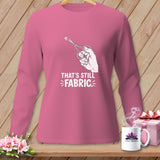 Pink long-sleeve shirt with graphic of scissors cutting fabric and text 
