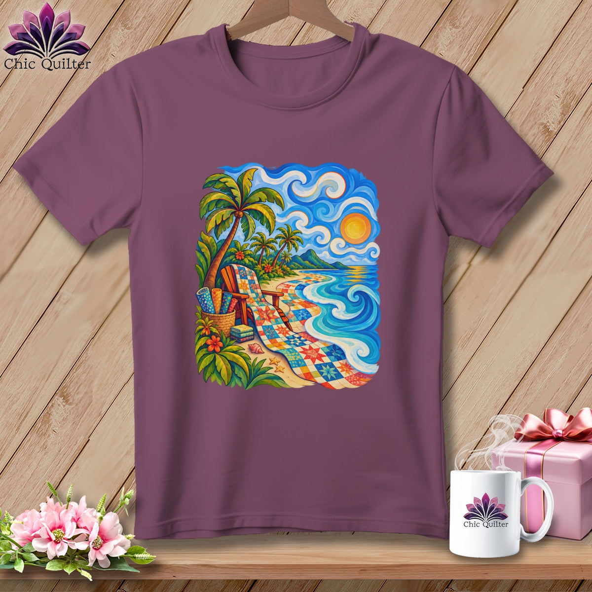 Plum-colored short-sleeve t-shirt on a wooden background, featuring a colorful coastal quilt-style graphic on the chest.