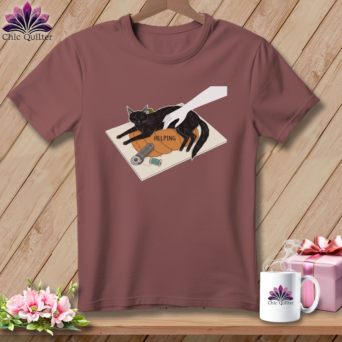 Black cat resting on pumpkin with text "HELPING" and sewing supplies.
