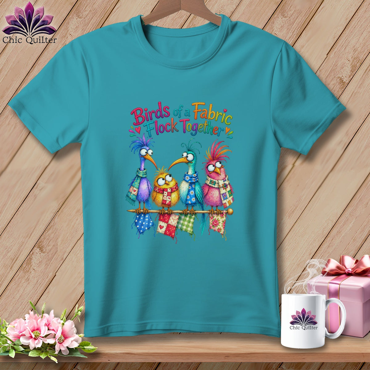 Teal t-shirt featuring a colorful graphic of four quirky birds sitting on a knitting needle with text.