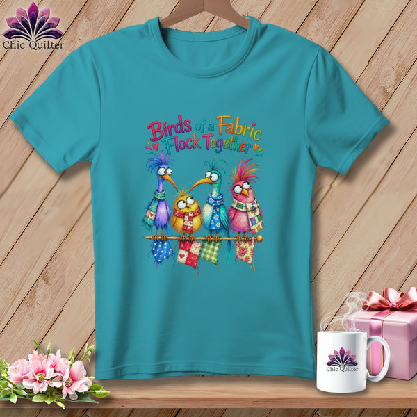 Teal t-shirt featuring a colorful graphic of four quirky birds sitting on a knitting needle with text.