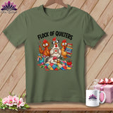 Olive green crewneck t-shirt featuring a cartoon illustration of cartoon chickens sewing, with the text Flock of Quilters.