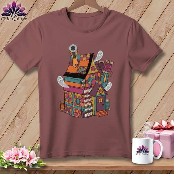 T-shirt with a book house design featuring ghosts and sewing supplies.