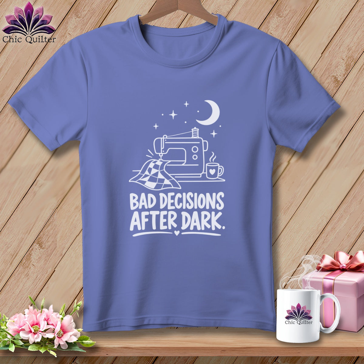 Periwinkle t-shirt with white graphic of sewing machine, quilt, mug, moon and stars, and text.