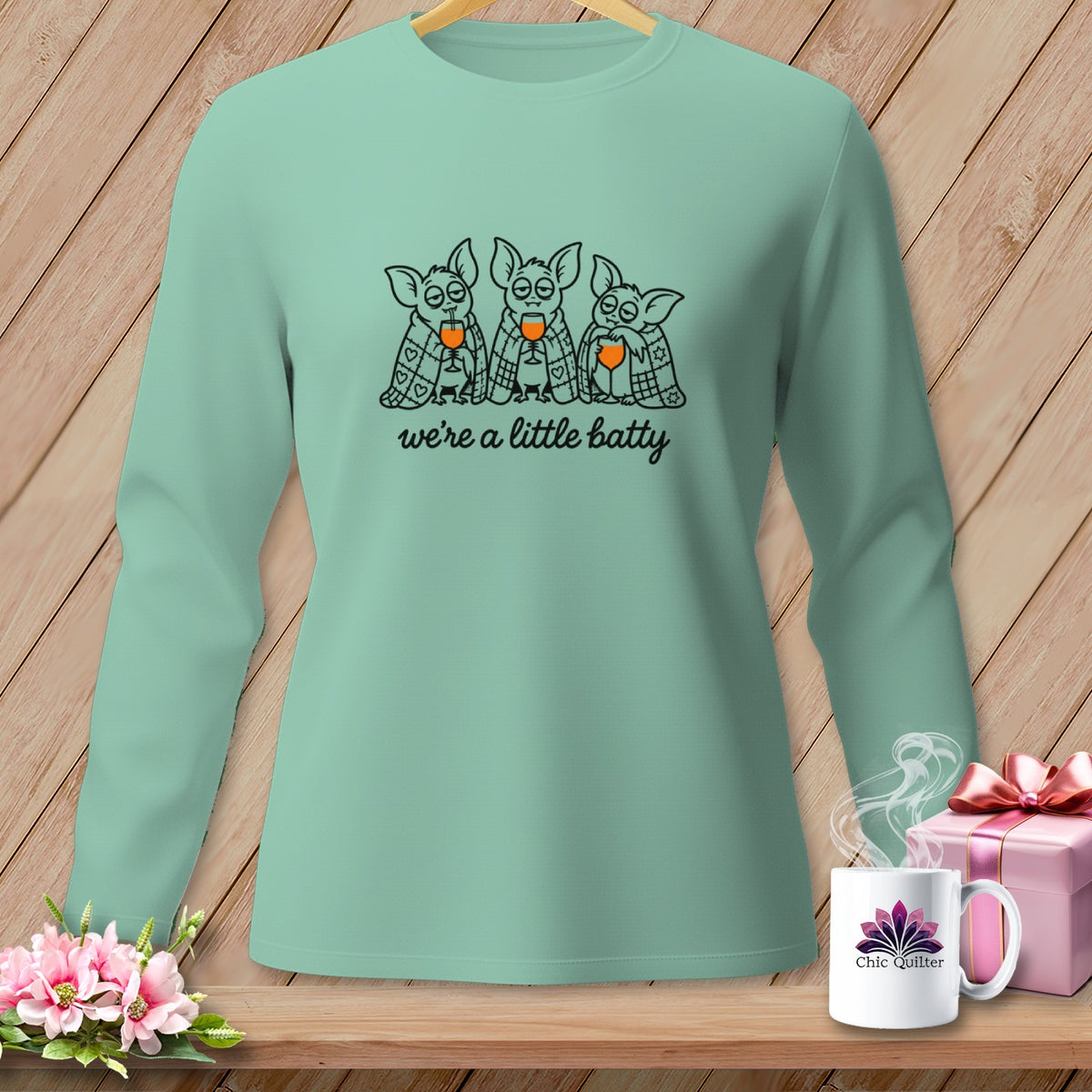 Mint long-sleeve shirt with a graphic of three bats drinking wine, saying "we're a little batty".